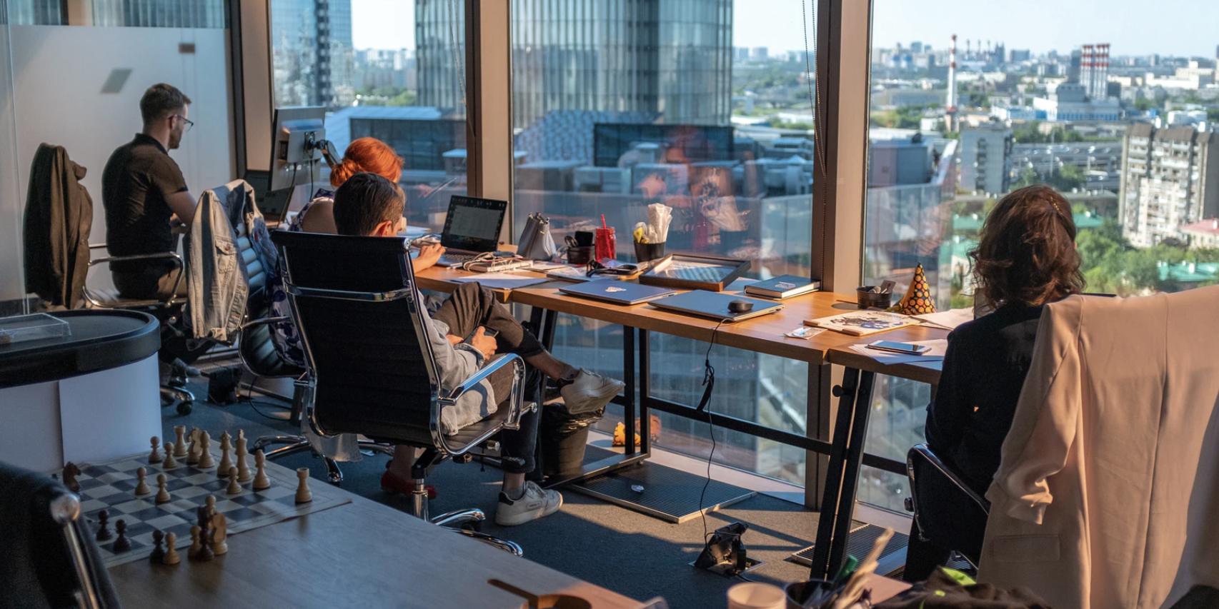 People working in front of computers with view of the city from office